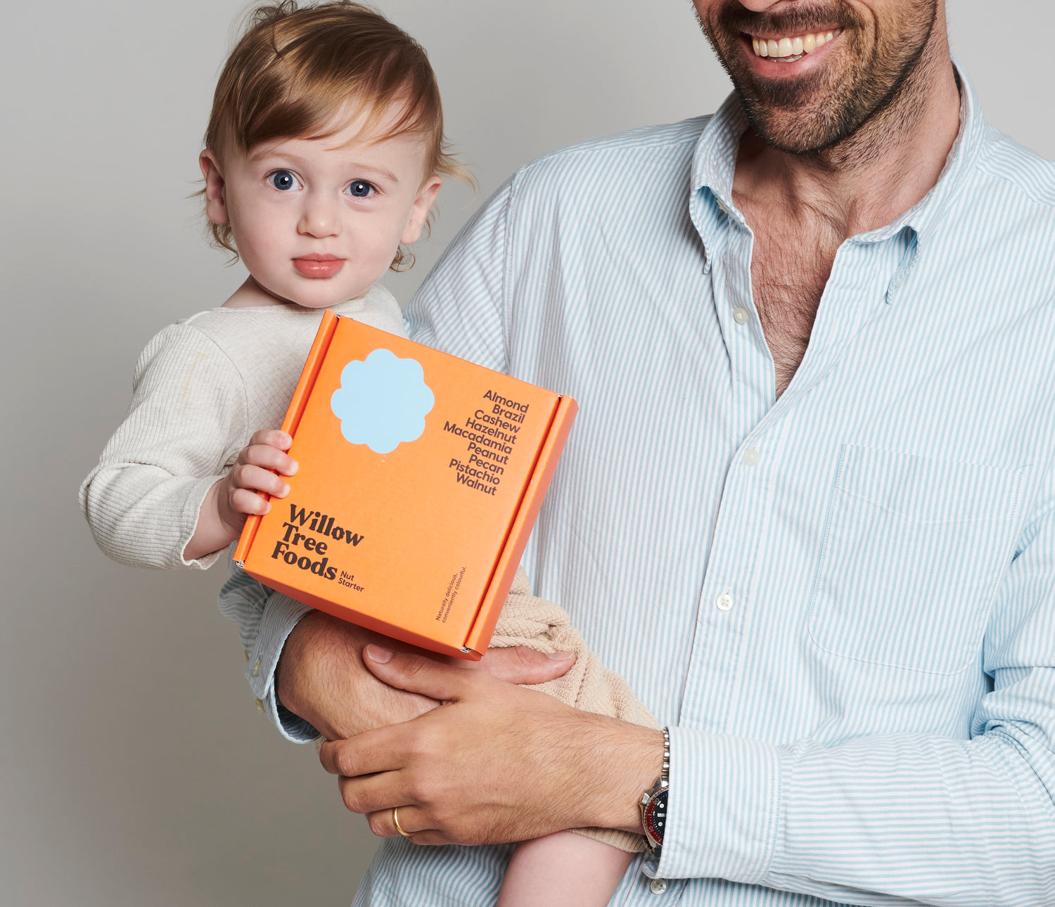 9 jars nut but starter kit held by a toddler and his father